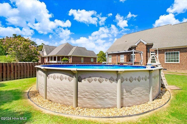 view of swimming pool with a yard