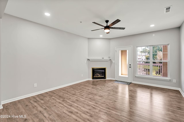 unfurnished living room featuring ceiling fan and wood-type flooring