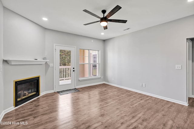 unfurnished living room with wood-type flooring and ceiling fan