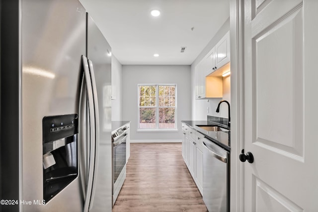 kitchen featuring light hardwood / wood-style floors, white cabinetry, sink, and appliances with stainless steel finishes