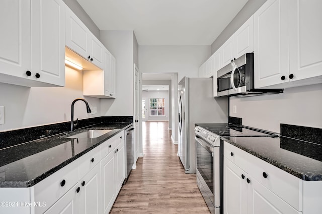 kitchen with sink, white cabinets, dark stone counters, and appliances with stainless steel finishes