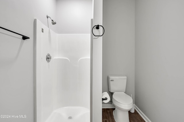 bathroom featuring wood-type flooring, toilet, and walk in shower