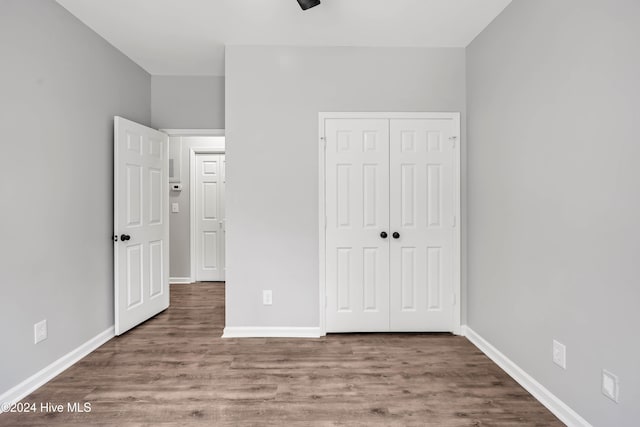 unfurnished bedroom with a closet and hardwood / wood-style flooring