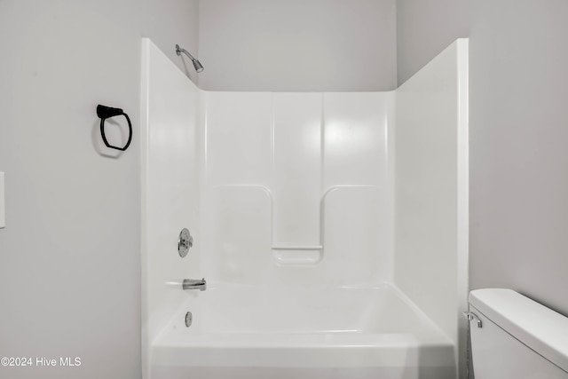 bathroom featuring bathtub / shower combination and toilet