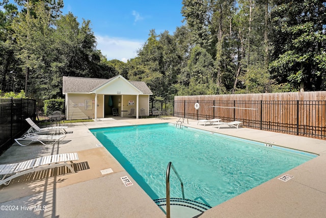 view of swimming pool featuring an outbuilding and a patio