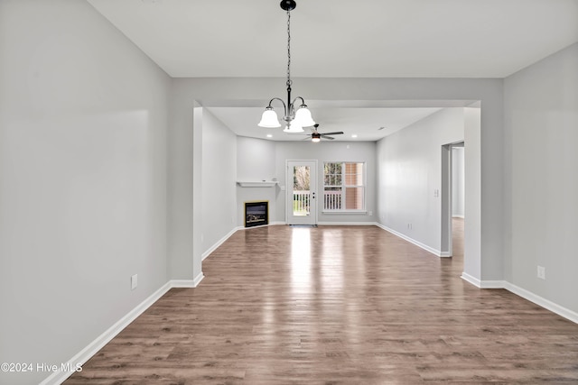 unfurnished living room with hardwood / wood-style floors and ceiling fan with notable chandelier