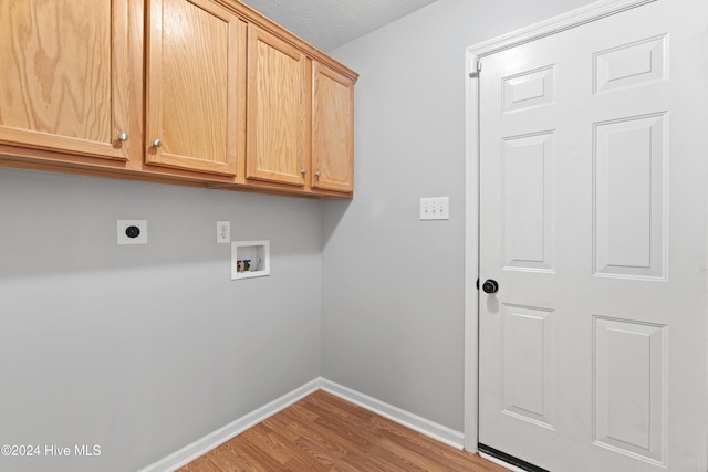 clothes washing area featuring cabinets, hardwood / wood-style floors, electric dryer hookup, and washer hookup