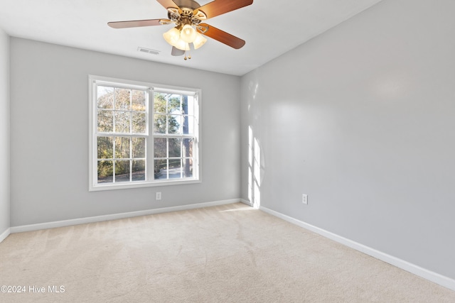 carpeted spare room featuring ceiling fan