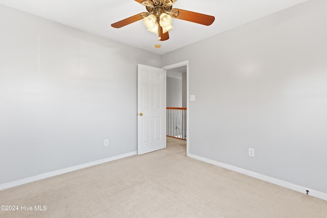 carpeted spare room featuring ceiling fan