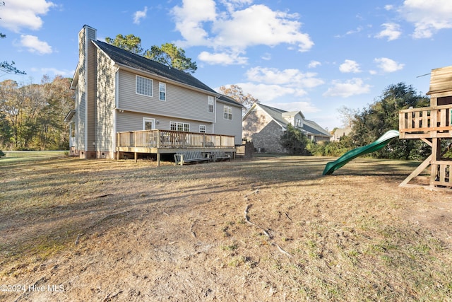 back of house with a yard, a playground, and a wooden deck