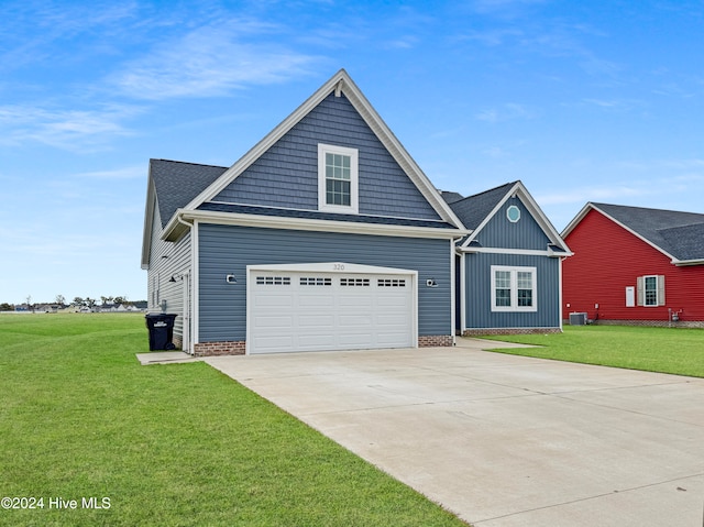 view of front facade featuring a front yard, a garage, and central AC unit