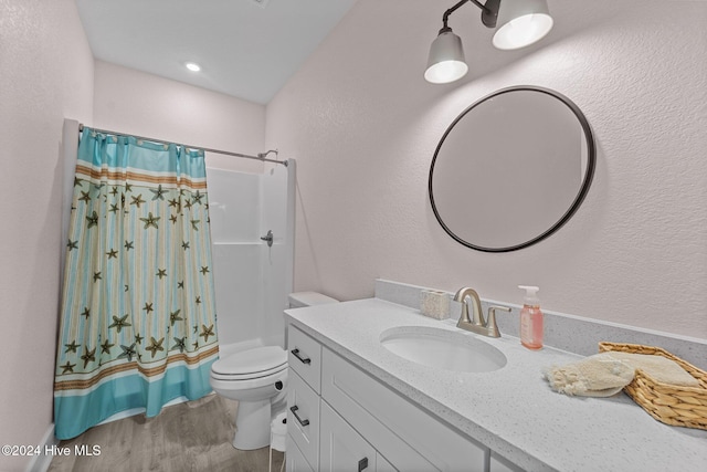 bathroom featuring walk in shower, vanity, wood-type flooring, and toilet