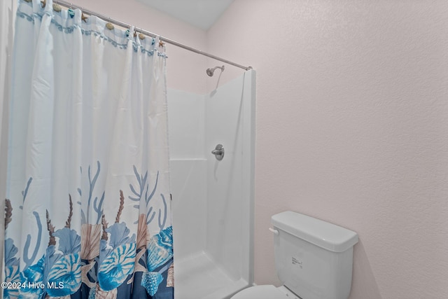 bathroom featuring toilet and walk in shower