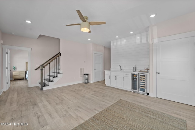 bar featuring white cabinets, light hardwood / wood-style floors, and wine cooler