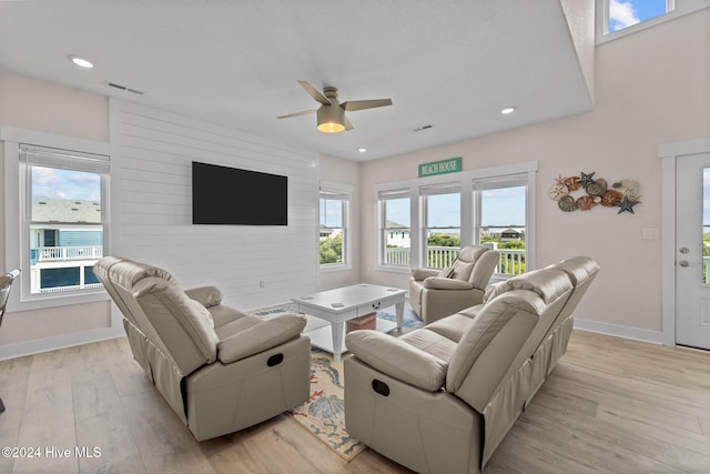 living room with ceiling fan and light hardwood / wood-style flooring