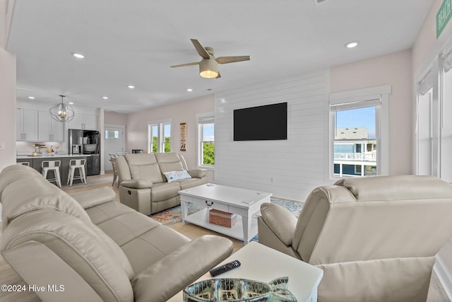 living room with ceiling fan with notable chandelier