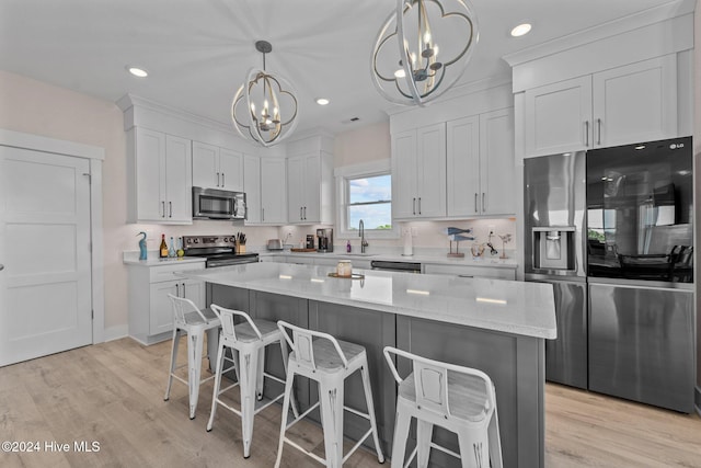 kitchen featuring pendant lighting, white cabinetry, a center island, and stainless steel appliances