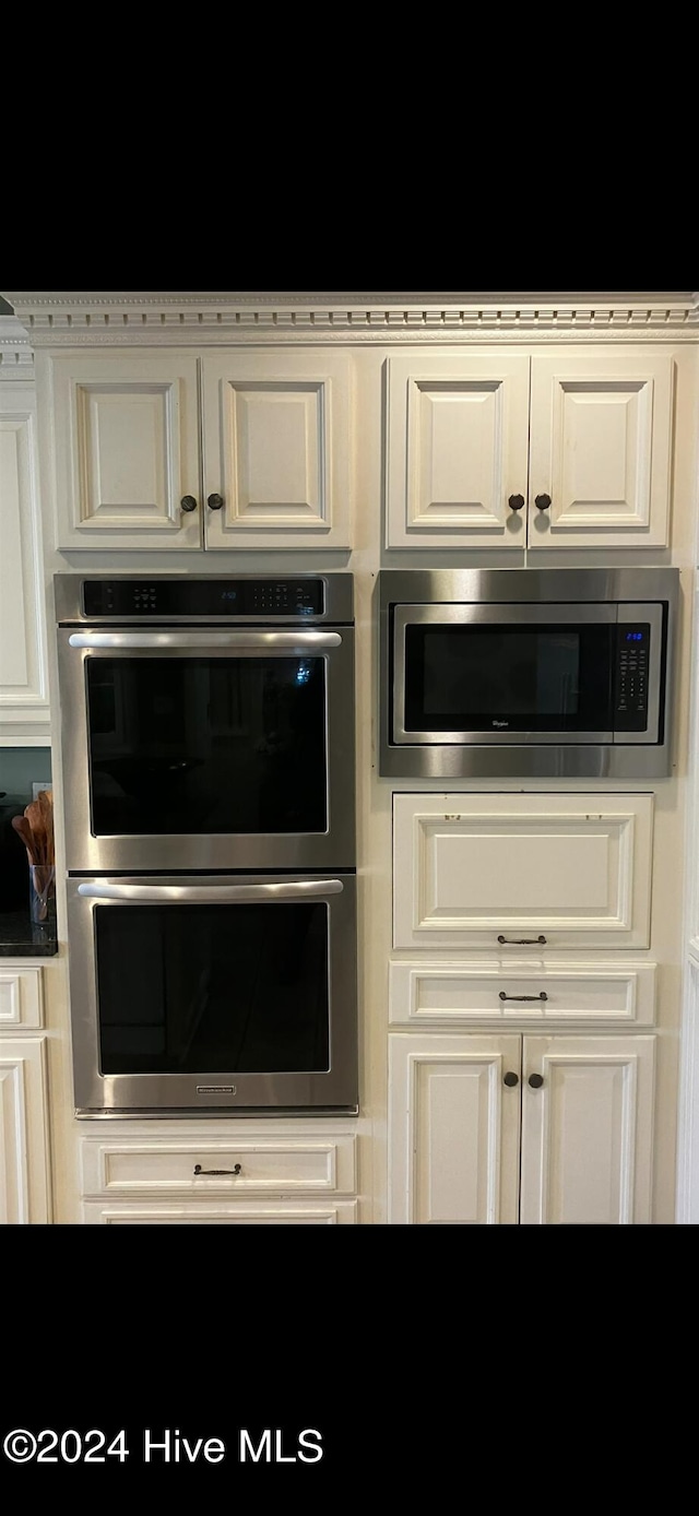 interior space with white cabinetry and appliances with stainless steel finishes