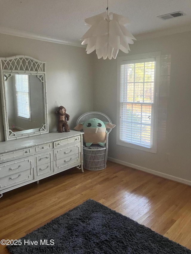 unfurnished bedroom featuring crown molding and light wood-type flooring