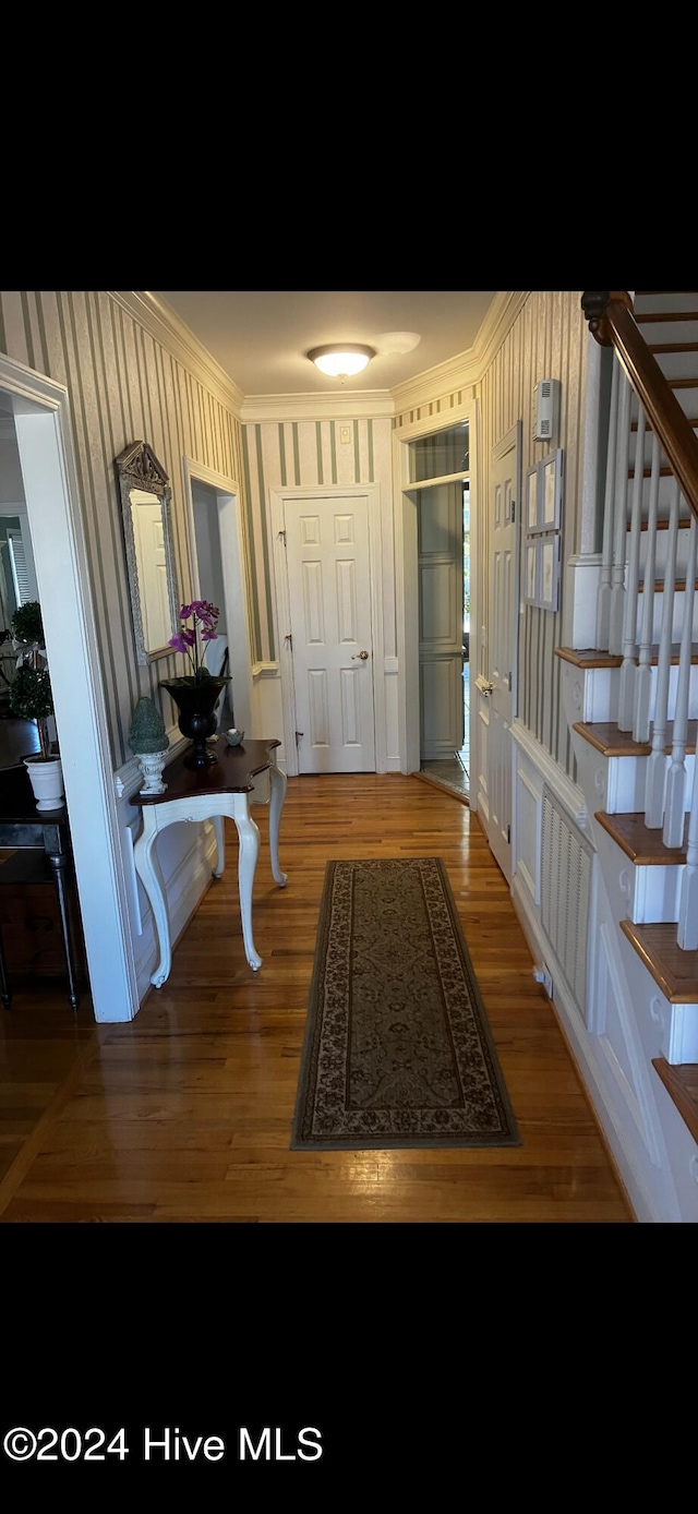 foyer with hardwood / wood-style floors and ornamental molding