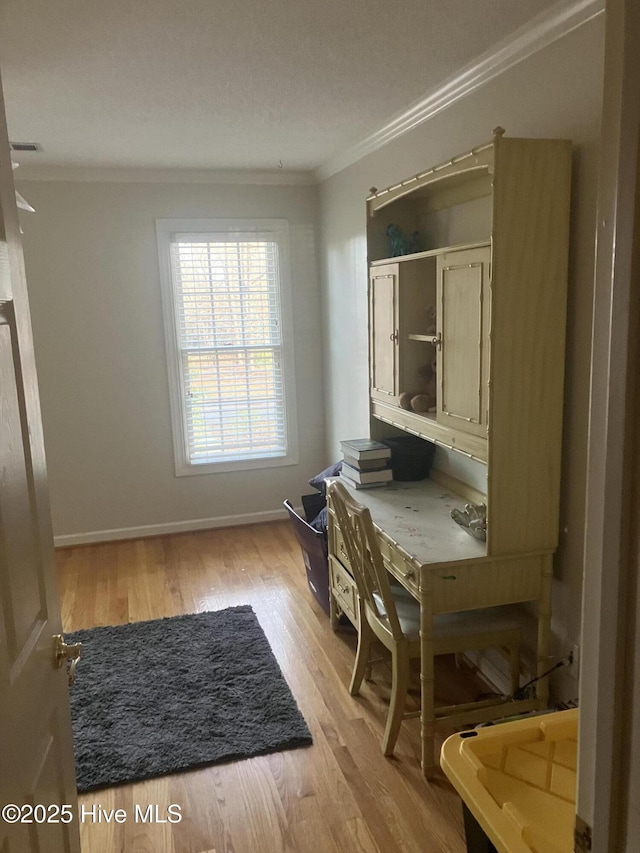 office space with ornamental molding and light wood-type flooring