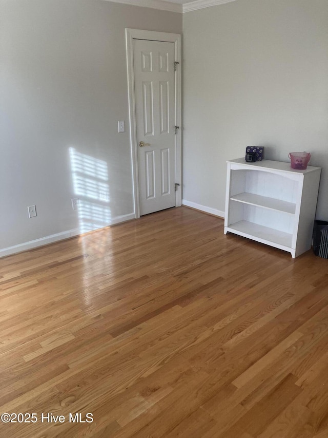 empty room with hardwood / wood-style floors and ornamental molding