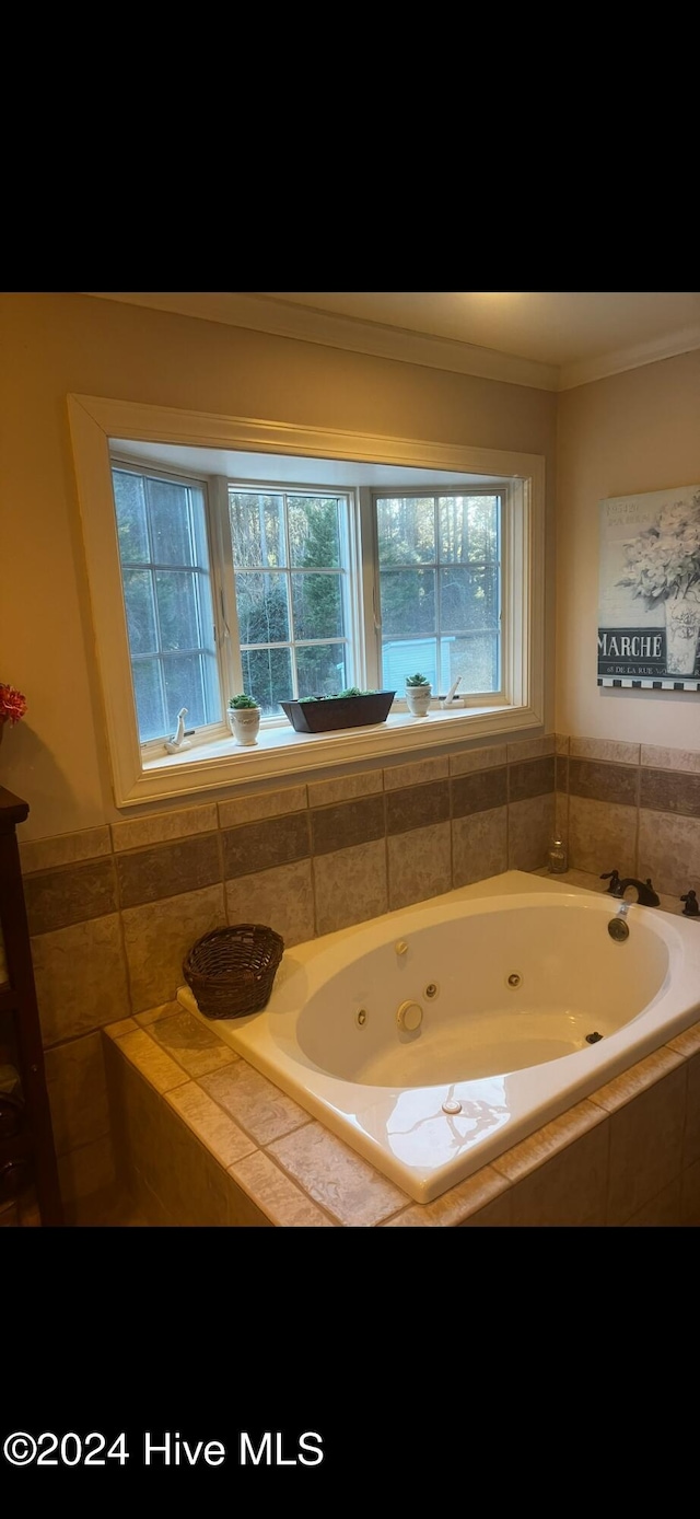 bathroom featuring tiled bath and ornamental molding