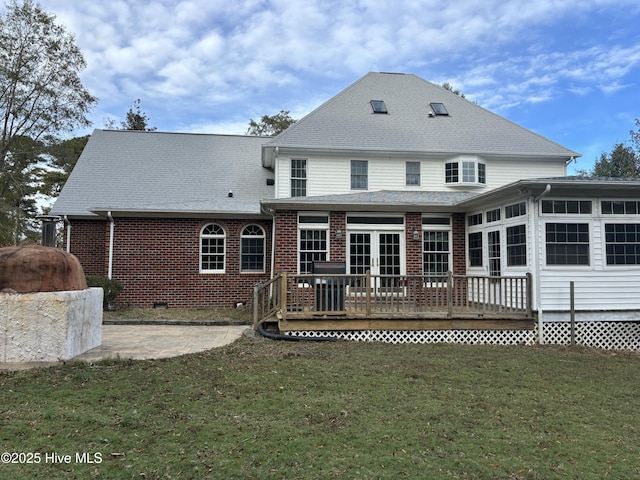 back of house featuring a patio, a wooden deck, and a yard