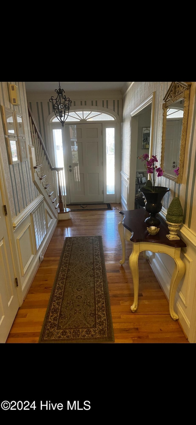 foyer featuring wood-type flooring and a notable chandelier