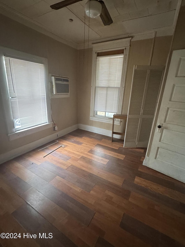 620 W Main St, Williamston, NC 27892 - empty room with an AC wall unit, ceiling fan, wood finished floors, ornamental molding, and baseboards
