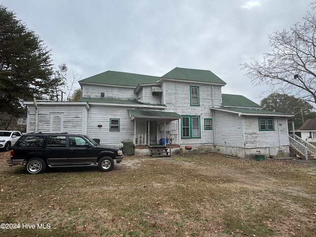 rear view of house featuring a yard