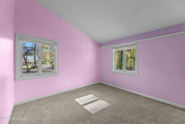 carpeted spare room with lofted ceiling