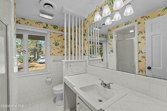 bathroom with vanity, tile walls, tile patterned flooring, toilet, and a shower with shower door