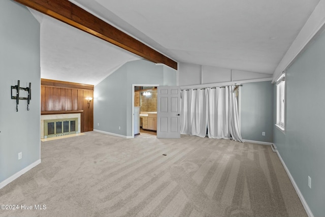 unfurnished living room featuring vaulted ceiling with beams and light colored carpet