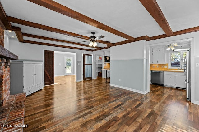 unfurnished living room with a fireplace, ceiling fan, dark hardwood / wood-style flooring, and beamed ceiling