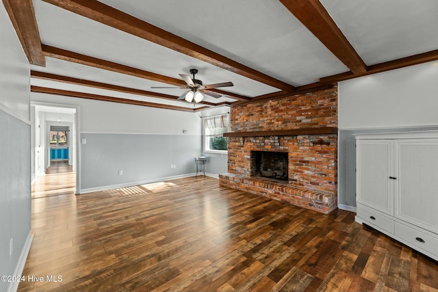 unfurnished living room with beam ceiling, dark hardwood / wood-style floors, a brick fireplace, and ceiling fan