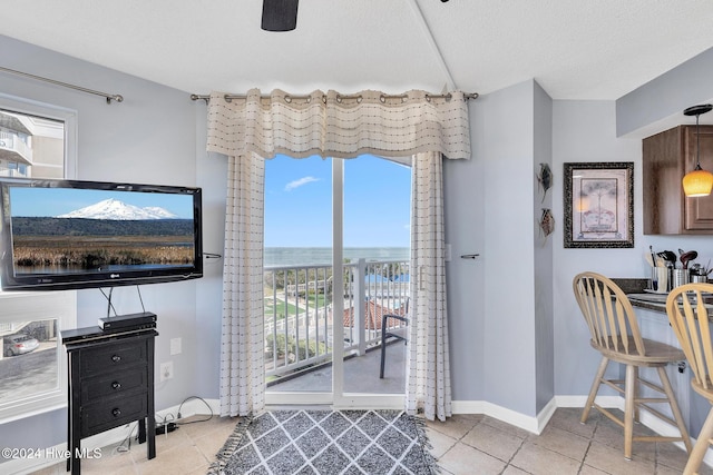 interior space with a textured ceiling, a water view, and plenty of natural light