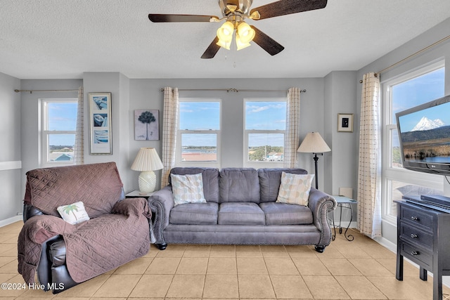 tiled living room with a textured ceiling and ceiling fan