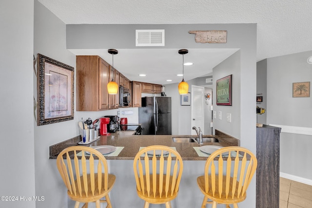 kitchen with black appliances, a kitchen bar, kitchen peninsula, and sink