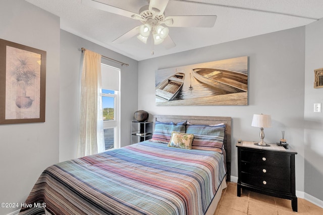 tiled bedroom with a textured ceiling and ceiling fan