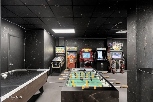 game room with concrete flooring and a drop ceiling