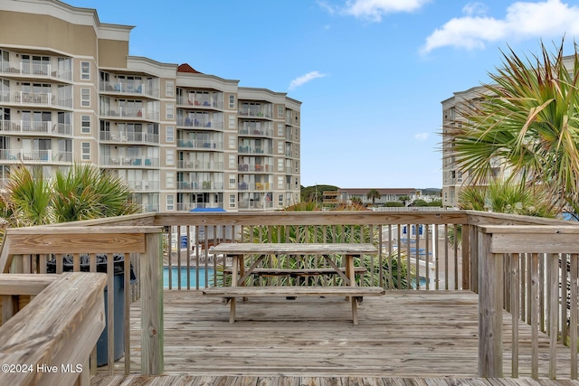 wooden terrace featuring a water view and a community pool