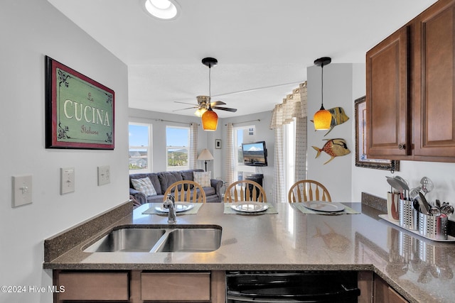 kitchen with kitchen peninsula, decorative light fixtures, ceiling fan, and sink