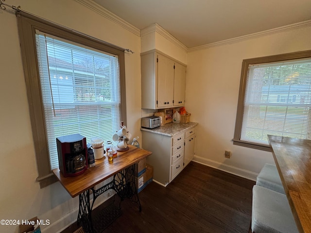 kitchen with dark hardwood / wood-style floors, light stone countertops, white cabinetry, and crown molding