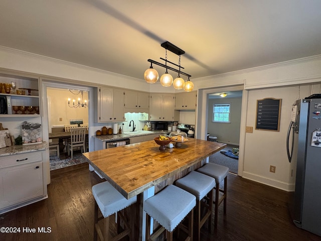 dining space featuring a notable chandelier, sink, dark hardwood / wood-style floors, and ornamental molding