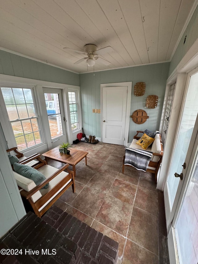 sunroom with ceiling fan and wooden ceiling