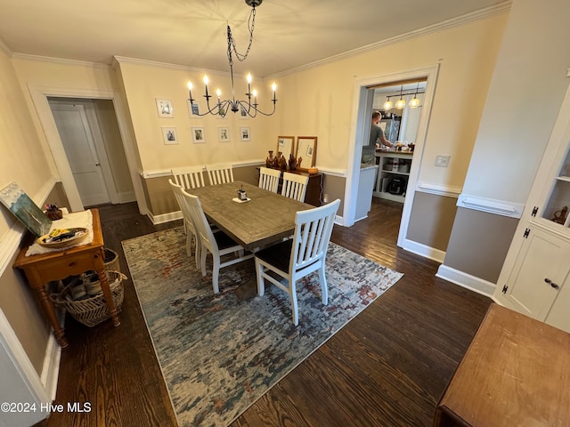 dining room with dark hardwood / wood-style floors, crown molding, and an inviting chandelier