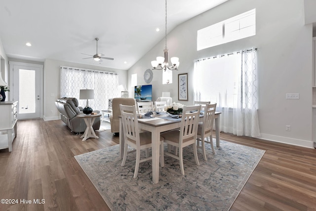 dining room featuring ceiling fan with notable chandelier, dark hardwood / wood-style floors, and high vaulted ceiling