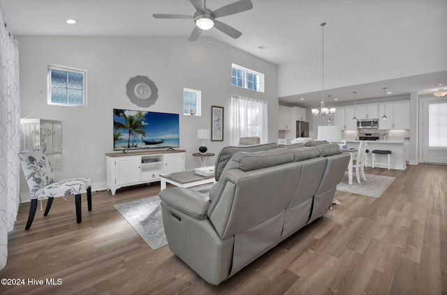 living room featuring a healthy amount of sunlight, high vaulted ceiling, and light hardwood / wood-style flooring