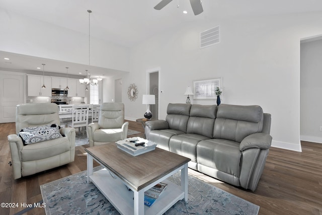 living room with ceiling fan with notable chandelier, dark hardwood / wood-style floors, and high vaulted ceiling